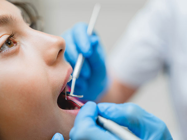 dentist checking the girl's teeth