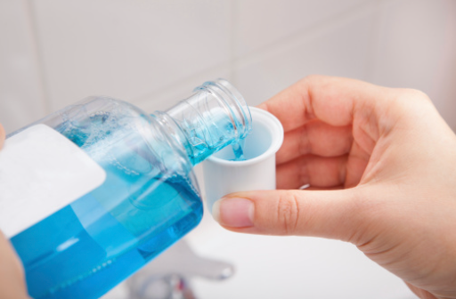 person pouring mouthwash into the cap